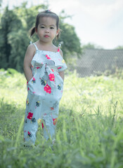 Beautiful cute asian little girl in the morning on the meadow