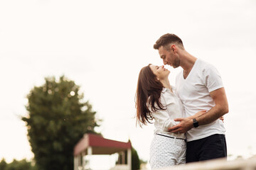 beautiful young couple hugging and kissing outdoors in the park on a warm summer sunny day. Love story