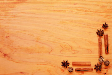 Festive background with spices arranged in a corner of a wooden board.