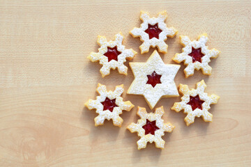 Obraz na płótnie Canvas Homemade linzer cookies in a shape of snowflakes and star filled with strawberry jam, top view, copy space