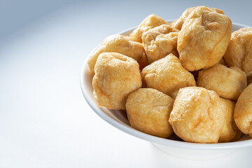 Close-up of a bowl of golden tempting fried tofu with avocado oil