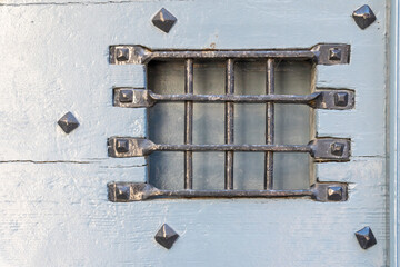 la grille enfer forgé de la porte en bois bleue