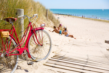 Enfants sur la plage au soleil en été pendant les vacances, vieux vélo rouge sur le bord du...