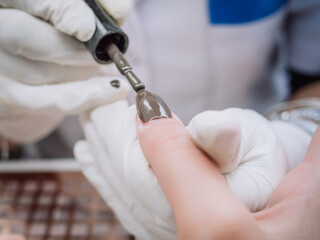 Professional manicure in salon. professional esthetician applies  permanent polish on nails. Beautician women. Cosmetology.