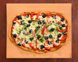 homemade pizza, vegetarian food, baked vegetables and cheese, tomatoes and olives, delicious food on a wooden background