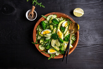 Green salad with avocado, cucumber, broccoli. Healthy organic vegan salat. top view
