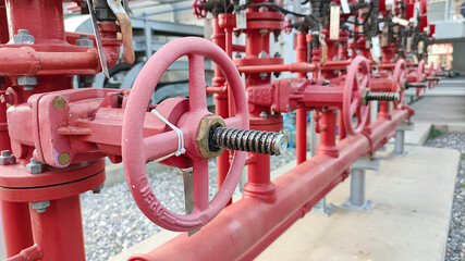 The red hand wheels of metal valve in the factory. Red valve in factory with the fire hose used for...