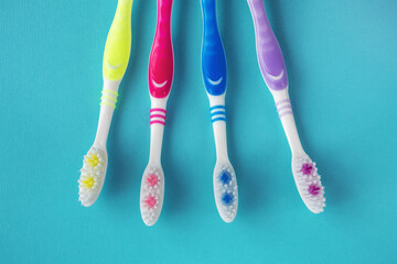 Four clean toothbrushes on a blue background. Toothbrushes for the whole family