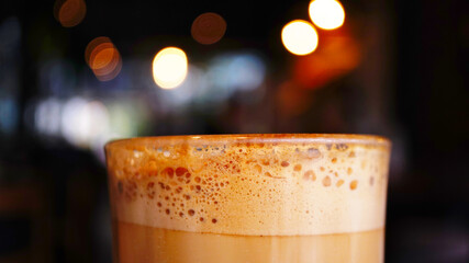Close up a glass of latte coffee with blur background cafe.