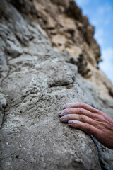 Adult male handholding on to a rock