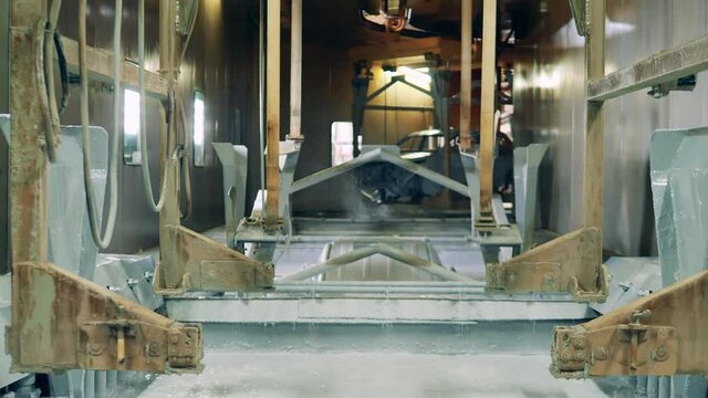 Factory unit with zinc solution and a car body getting submerged into it