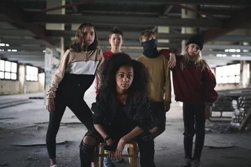 Foto op Aluminium Group of teenagers gang standing indoors in abandoned building, bullying concept. © Halfpoint