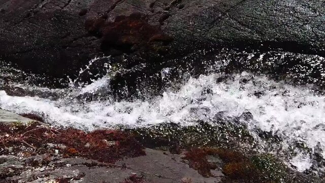 4k video of a powerful water flow from a mountain river in Peru, Lagunas (Lakes) of Pichgacocha, Ambo, Huanco. Located above 4000 meters. Black and grey rocks. Truck right to left. wide angle shot
