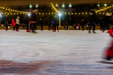 Blurred christmas background of people skating on ice rink