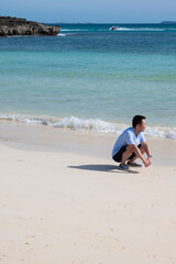 A Japanese man walks on a beach in Irabu Island, Miyakojima, Okinawa, Japan
