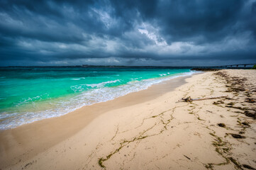Storm clouds contrast with the turquoise waters and white sandy beaches of Kurima Island, Miyakojima, Okinawa, Japan