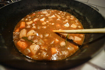 Stockholm, Sweden Vegetarian stew cooking on a stovetop in a large pot.