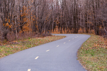 Multifunctional paved two-way path curving in the De la Martiniere Park in the Fall, Levis, Quebec, Canada