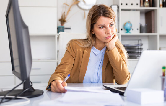 quizzical adult female manager working with docs