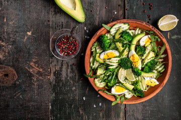 Vegetable salad with avocado, cucumber, arugula, lime, broccoli. Top view with copy space