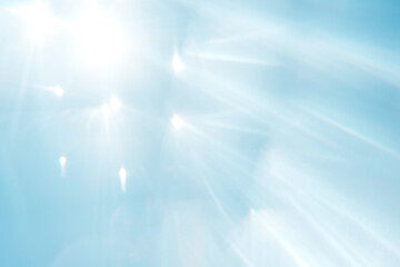 Blue blurred background with sun rays.