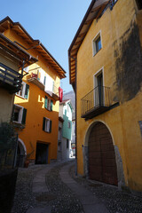 old cobblestone street in between colorful buildings in Ticino
