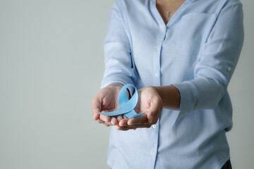 November light blue ribbon on woman hand with copy space, Prostate cancer awareness month, men's...