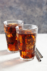 glass of cold cola soft drink with ice on concrete background