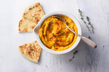 Delicious healthy homemade bean hummus with baked pumpkin, tahina and spices with flat bread on a...