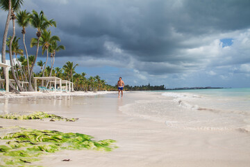 Man walking on white sandy beach