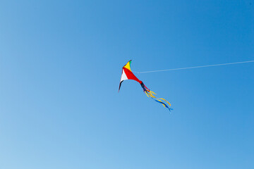kite on the blue sky in sunny weather and wind. Kite flying in summer with copy space. Liberty.