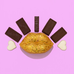 Minimal flat lay art. Fake golden lips and .chocolates mix composition.  Sweet lover concept