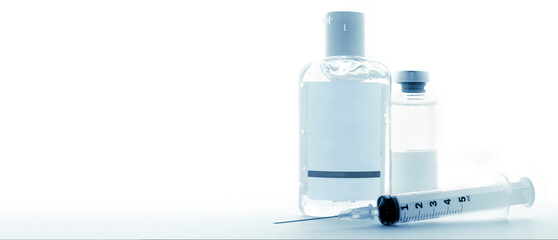 Blank label sanitizing gel bottle and medicine vial with a hypodermic syringe on a 16:9 banner