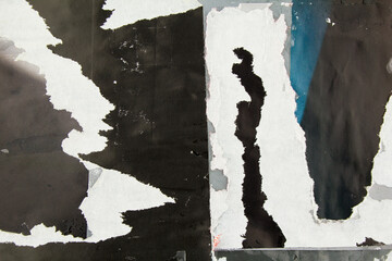 Black torn and crumpled magazine paper with dirty glue marks and stains. Abstract background with...