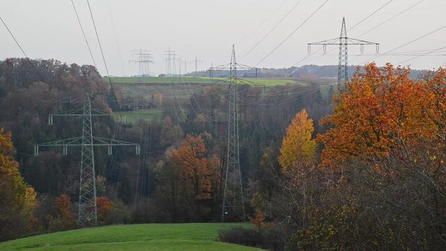Large transmission towers in the countryside. Different types of electricity pylons in the countryside. Large electricity poles in an autumn landscape.