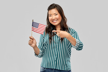 independence day, patriotism and national people concept - happy asian woman with flag of america over grey background