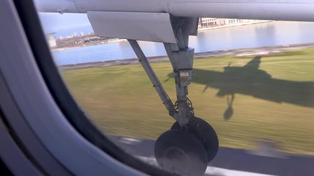 Aircraft taxiing taking off from an airport and landing gear retracting