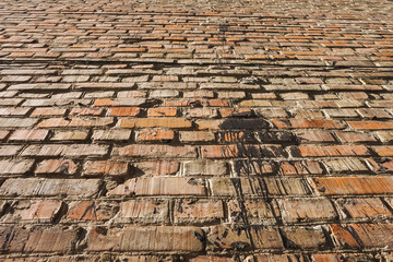 Brick wall background. Texture of an old brick wall with resin stains. Bottom view, perspective