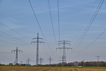 Large transmission towers in the countryside. Different types of electricity pylons in the countryside. Large electricity poles in an autumn landscape.