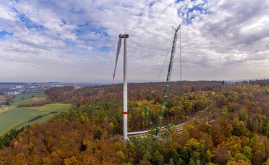 Drone image of a wind turbine under construction in a forest area in Germany