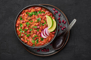 Rajma Masala Curry in black bowl on dark slate table top. Red Kidney Bean Dal is indian cuisine vegetarian dish. Asian food, meal. Top view