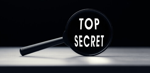 Magnifying glass with the text Top Secret on table