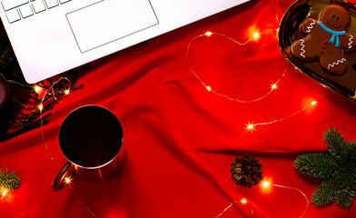 Christmas or New Year concept frame on the red blanket with a keyboard and festive decoration. Top view. Copy space