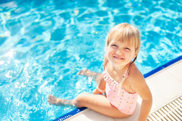 Fototapeta na wymiar little blonde girl in the pool 