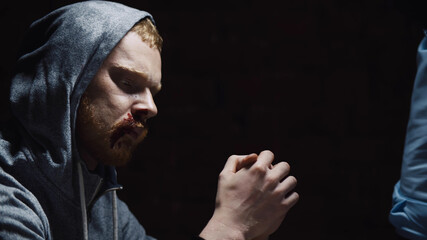 Close up of aggressive african cop bullying suspect man during interrogation