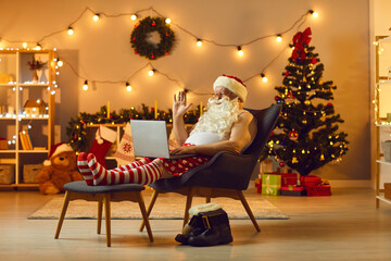 Senior Santa in funny home festive costume chatting online with family