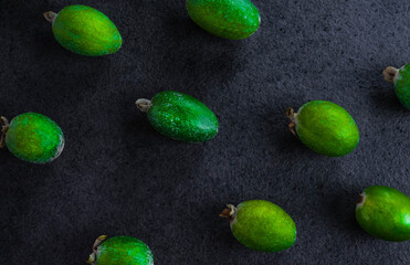 Fresh feijoa on a black stone background. Top view