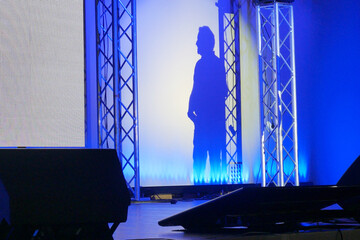 man makes a report on stage at a conference or business seminar, speaker shadow