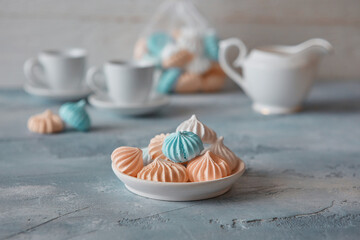 Romantic Breakfast with meringue cookies, white cups and creamer
