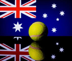 Yellow Tennis Ball on black mirror with Australian Flag in the background